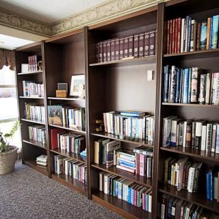 A cozy library corner with wooden bookshelves filled with a variety of books.