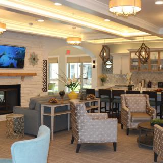 A spacious and modern lounge area featuring comfortable seating, a fireplace, and a television.