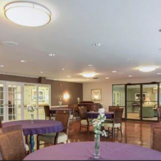 A well-lit dining area with tables and chairs arranged neatly, featuring decor and soft lighting.