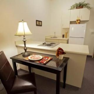 Cozy kitchen and dining area with a small table and lamp.