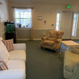 A cozy living room with sofas, armchairs, a fish tank, and decor.