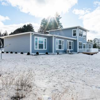 A modern house surrounded by a snowy landscape under a clear sky.