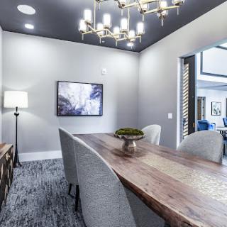 A stylish dining room featuring modern decor, a wooden table, and an elegant chandelier.