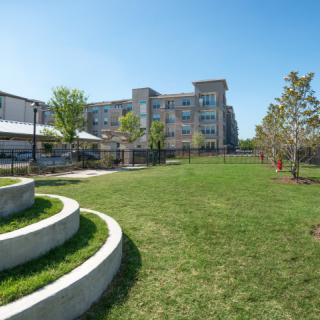 A modern building surrounded by well-maintained grass and trees, providing a pleasant outdoor space.