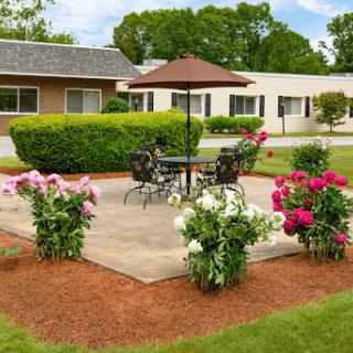 A charming garden patio with vibrant flowers and a comfortable seating area, perfect for relaxation.