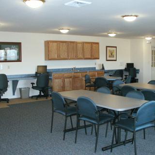 A conference room setup with tables, chairs, and computer stations.