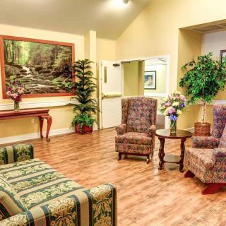 A cozy lobby with comfortable seating, decorative plants, and wall art.