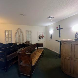 A serene interior of a church or chapel featuring wooden benches and a pulpit.