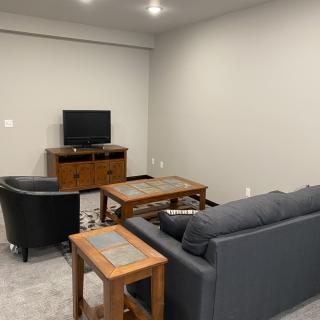 A cozy living room with modern furniture and a television setup.
