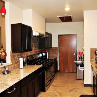 A sleek, modern kitchen featuring black cabinetry and granite countertops.