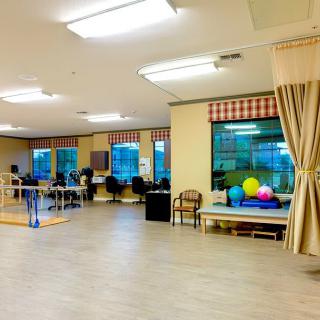 A spacious therapy room equipped with exercise equipment for rehabilitation exercises.