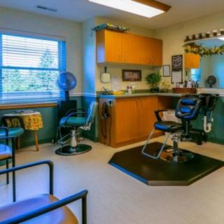 A cozy barbershop with a single chair, mirror, and a small waiting area.