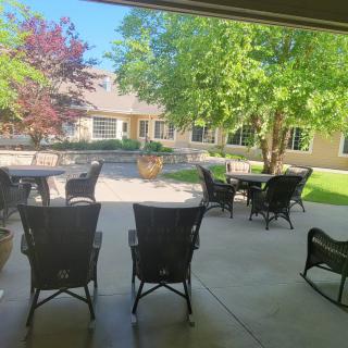 A serene patio with outdoor seating surrounded by lush trees in a courtyard.