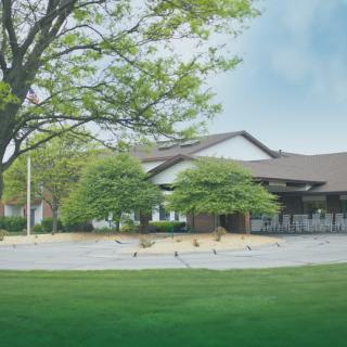 A scenic view of a building surrounded by lush greenery and a clear sky.