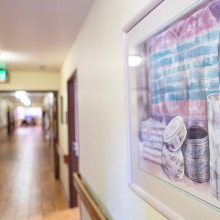 A building hallway with framed artwork on the wall.