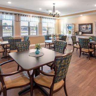 A well-lit dining area with modern furnishings and large windows.