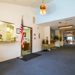 A spacious lobby area with a reception desk and an American flag on display.