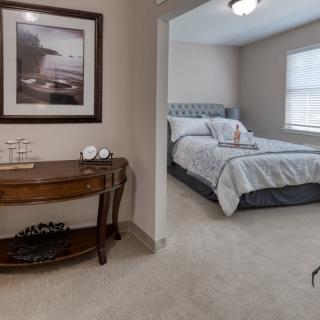 A cozy bedroom with a neatly made bed and decorative elements.