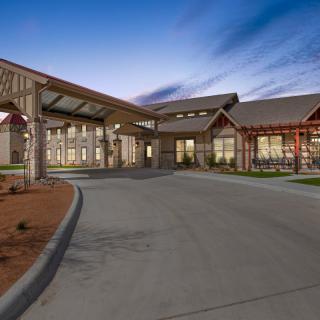 A modern building exterior with a welcoming entrance and driveway at dusk.