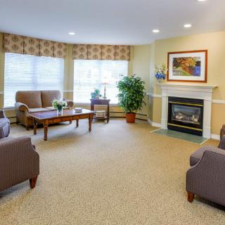 A cozy living room with comfortable seating, a fireplace, and large windows.