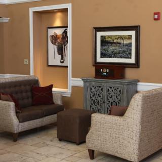A cozy seating area featuring comfortable chairs and elegant artwork on the walls.