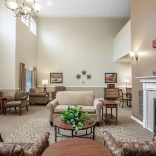 A cozy and well-decorated living room with a sofa, coffee tables, and a fireplace.