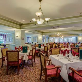 A spacious and elegantly decorated dining room with neatly arranged tables and chairs.
