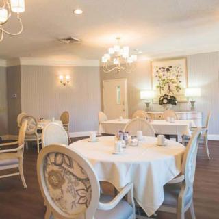 An elegantly decorated restaurant dining room with chandeliers and beautifully set tables.