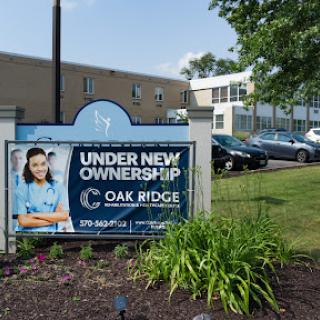 A sign indicating that Oak Ridge is under new ownership, displayed in front of the facility.