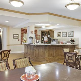 A cozy dining area with wooden furniture, decorative items, and a central counter.