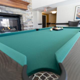 A billiards table in a well-furnished game room.