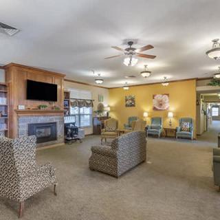 A cozy living room with ample seating, featuring a fireplace and television.