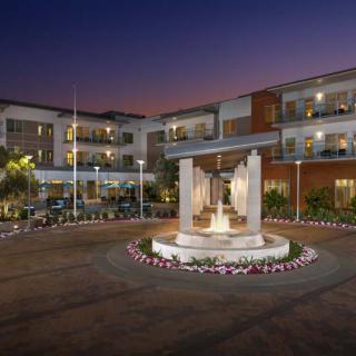 A well-lit hotel courtyard at night featuring a central fountain and modern architecture.