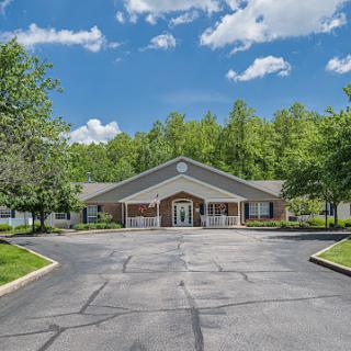 A well-designed building surrounded by lush greenery and a clear blue sky.