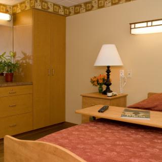 A cozy and well-furnished room featuring a bed, lamp, and decorative elements.