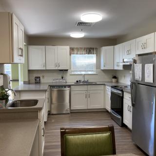 A modern kitchen with white cabinets and stainless steel appliances.