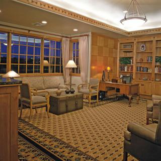A cozy living room with comfortable seating, bookshelves, and warm lighting.