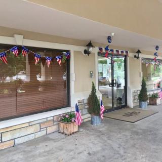 A decorated storefront entrance with patriotic flags and bunting.
