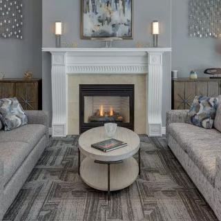 A modern living room featuring a fireplace, two sofas, and a round coffee table.