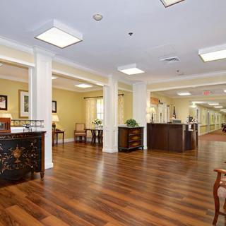 A spacious and well-lit lobby area with wood flooring and elegant furniture.