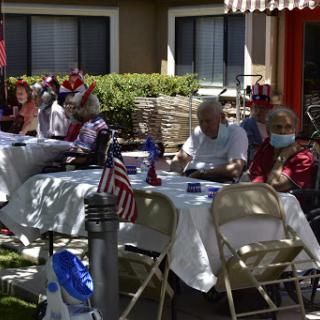 Residents enjoying a festive outdoor gathering, complete with decorations and American flags.