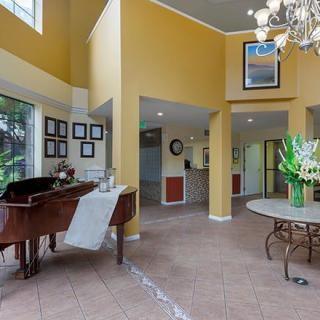 Spacious living room with a grand piano and elegant decor.