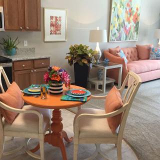 A cozy dining and living space with vibrant decor and a neatly set table.