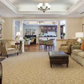 A spacious and elegantly designed living room with comfortable seating and a chandelier.