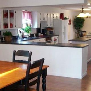 A spacious kitchen and dining area with white cabinetry and modern appliances.