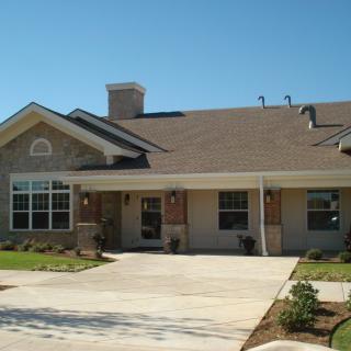 A suburban residential house with a driveway and landscaped front yard.