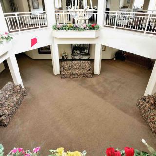 A spacious atrium with balconies and decorative plants, featuring an open interior design.