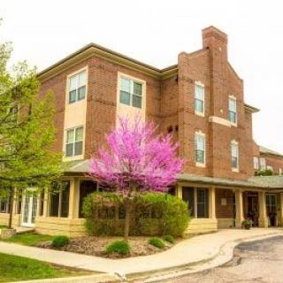 A brick building with a flowering tree in front, capturing the essence of spring.
