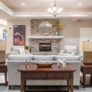 A cozy and well-designed living room featuring comfortable sofas, a stone fireplace, and elegant decor.