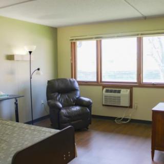 A cozy room with a comfortable chair and large window.
